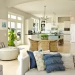 Coastal style family, dining room and kitchen with neutral colored finishes and blue fabric accents